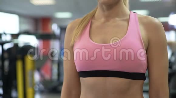 健身女性在健身房锻炼前清理健康手镯的指标视频的预览图