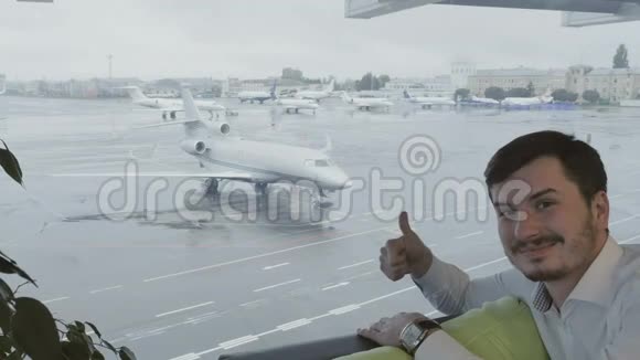 机场的可爱男子对着镜头竖起大拇指视频的预览图