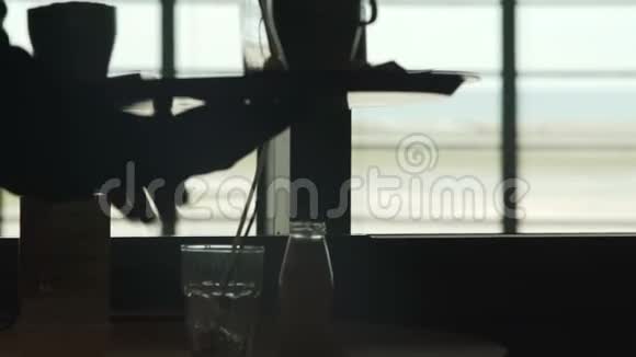 机场的咖啡厅服务员把杯子和咖啡杯放在桌子上服务视频的预览图