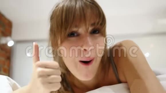躺在床上的女人竖起大拇指闭上脸视频的预览图