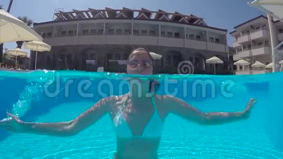 穿着白色泳衣的女孩在泳池里游泳视频的预览图