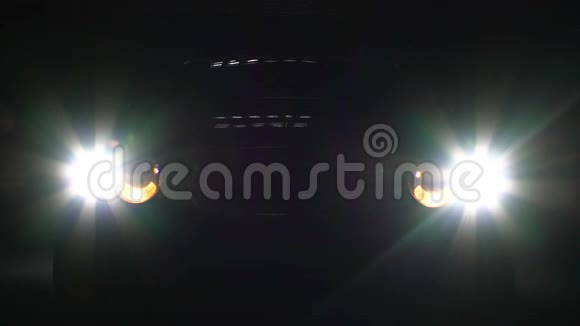 汽车前照灯在黑暗中开关明亮的前照灯照明视频的预览图