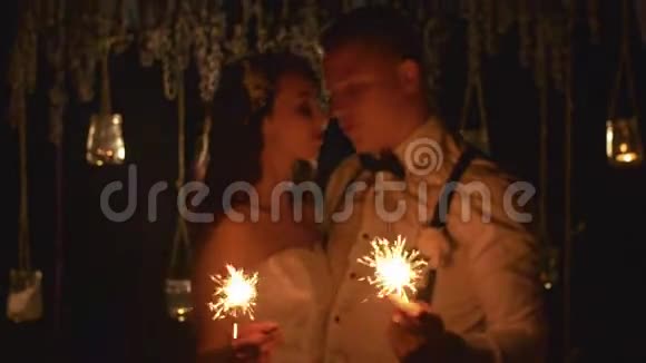 幸福的夫妻在户外燃烧孟加拉灯在这段时间里新郎和新娘用爱看着对方视频的预览图