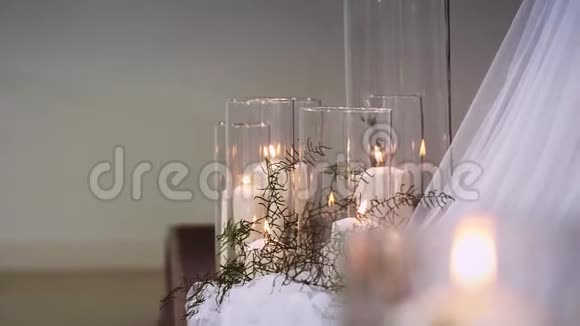 厚厚的燃烧的蜡烛矗立在透明的花瓶里周围是纺织品视频的预览图