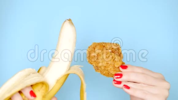 健康和不健康食品的概念香蕉在油炸面包鸡腿上的明亮蓝色背景女性视频的预览图