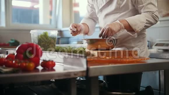 厨师在前台加入草药和香料蔬菜准备沙拉视频的预览图