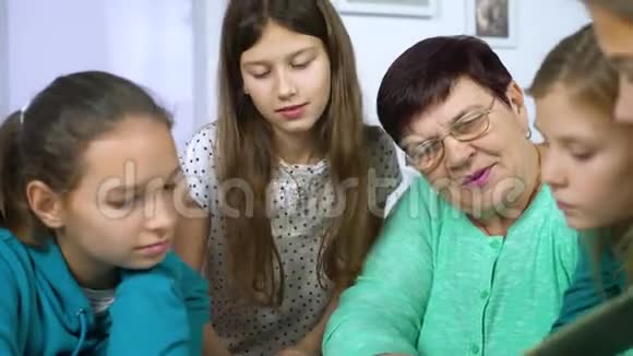 女孩们和祖母一起看旧相册视频的预览图