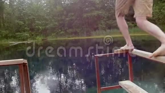 年轻人潜入清澈的蓝色湖泊视频的预览图