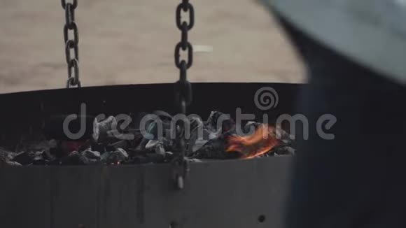 燃烧的煤块被灰灰覆盖放置在大的扁平黑色胸罩视频的预览图