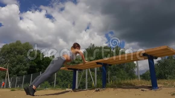 一名女运动员在公园长椅上做一些三头肌浸泡时的轮廓图视频的预览图