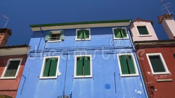 在破旧的蓝房子附近的花盆里种着许多花布拉诺岛的建筑视频的预览图