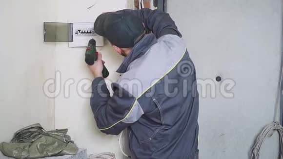 一名电工在工作中铺设带设备和工具的接线电缆螺丝刀视频的预览图