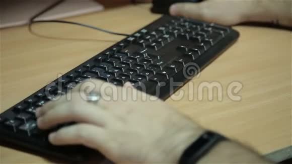 男人手在桌面键盘上打字视频的预览图