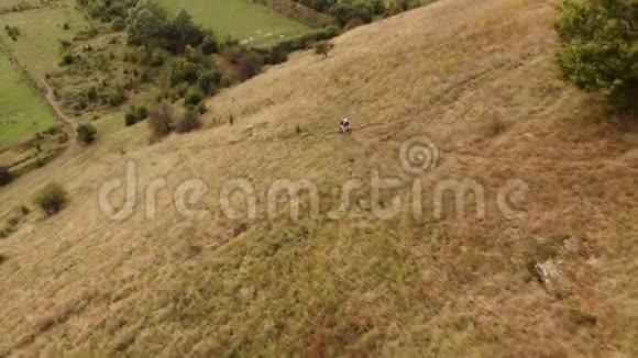 在实现目标的道路上莫托科罗斯自行车在日落山上爬空中观景4k视频的预览图