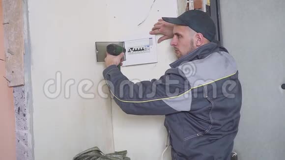 一名电工在工作中铺设带设备和工具的接线电缆螺丝刀视频的预览图