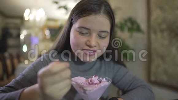 近距离观看胖乎乎的十几岁的黑发女孩吃紫罗兰色冰淇淋弄得乱七八糟微笑着肮脏的嘴唇视频的预览图
