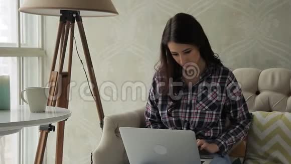 年轻女士坐在公寓里在网上商店买东西视频的预览图