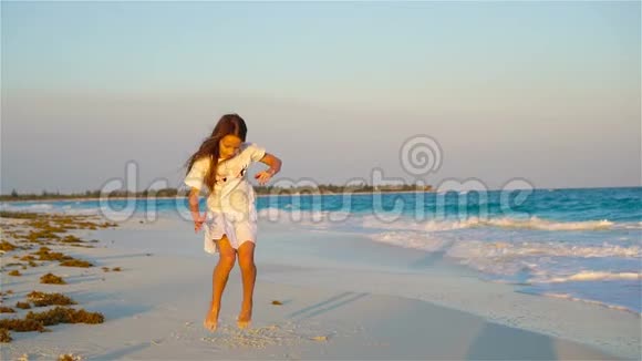 活跃的小女孩在海滩上玩得很开心在海边跳舞的孩子视频的预览图