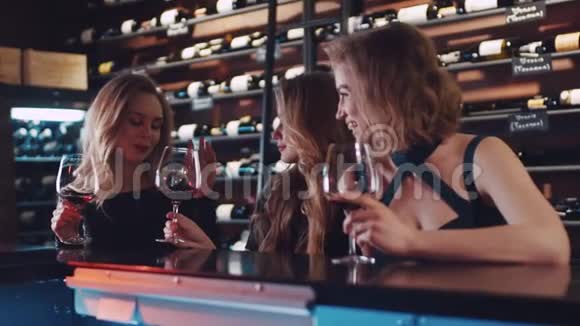 年轻漂亮的女朋友在酒吧里聊天带着一杯红酒女性友谊放松视频的预览图