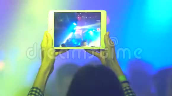 女人用平板电脑录制现场音乐会视频的预览图