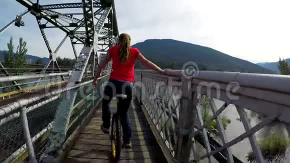 在桥上骑独轮车的女人视频的预览图