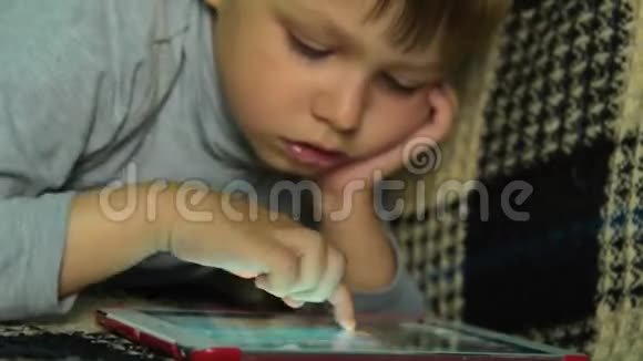 儿童在数码平板电脑上搜寻游戏视频的预览图