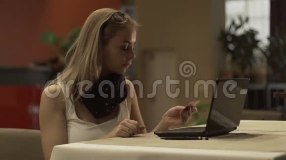 使用塑料银行卡和笔记本电脑上网购物的年轻女性视频的预览图