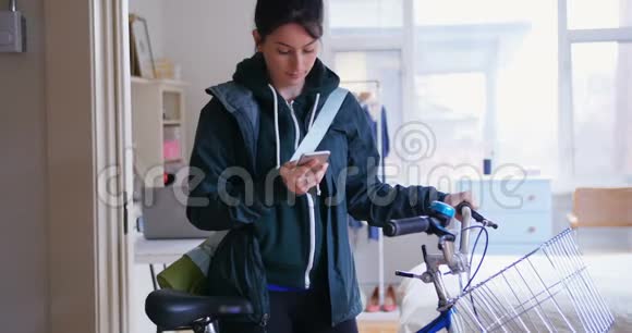 女人用手机把自行车拖出去视频的预览图