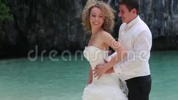 新娘穿白色连衣裙与新郎拥抱她视频的预览图