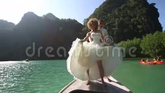 金发碧眼的新娘挥舞着长长的婚纱就像在卡巴雷站在长尾船上一样视频的预览图