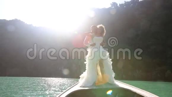 新娘和新郎之吻站在后光的长尾船上视频的预览图