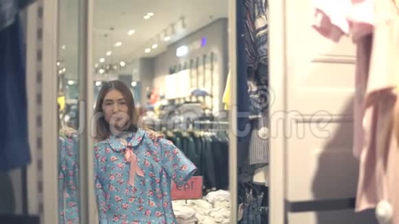 快乐的亚洲女人在商场或服装店挑选衣服和镜子视频的预览图