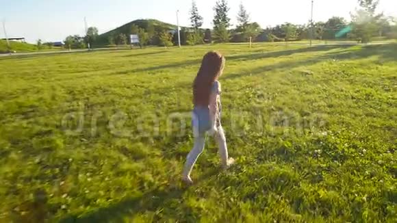 慢动作跑着快乐的小女孩绿色草地视频的预览图
