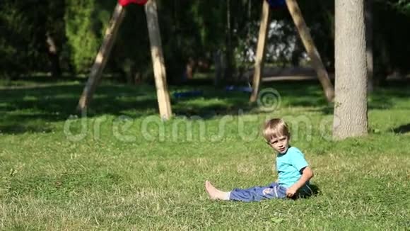 悲伤的男孩坐在草地上视频的预览图