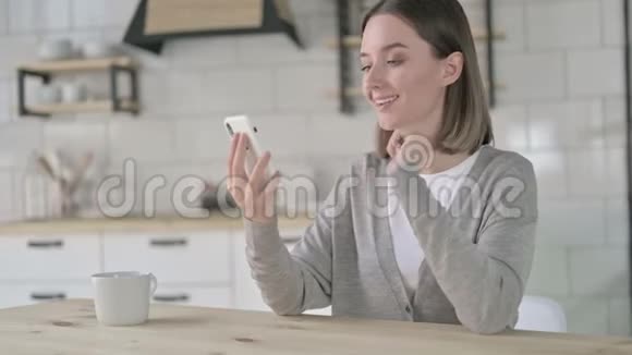 成功年轻女性在智能手机上庆祝视频的预览图
