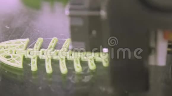 关闭3D打印机同时打印鱼形鱼的塑料骨架位于白色的背景上它印在视频的预览图