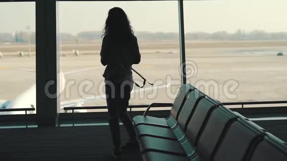 一个背着背包的旅游女孩在等待航班视频的预览图