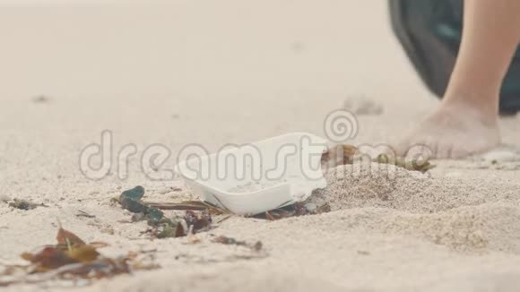 在白色海洋海滩上捡塑料的志愿者特写志愿者打扫海滩把垃圾堆起来视频的预览图