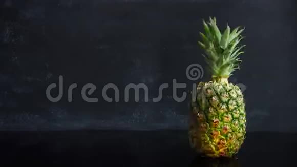 停止在黑色背景上运动成熟的热带水果菠萝延时食物循环镜头视频的预览图
