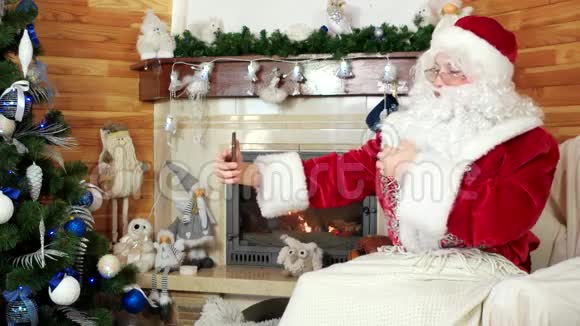圣诞老人通过skype交谈圣诞老人使用小工具装饰圣诞树传递快乐的吻视频的预览图