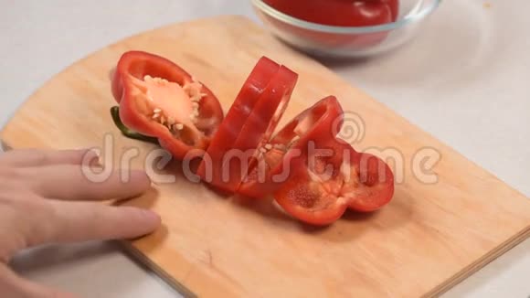 男人的手把红椒切在切割板上放在玻璃碗里视频的预览图