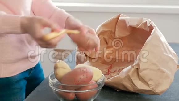 无法辨认的女人剥土豆皮侧视视频的预览图