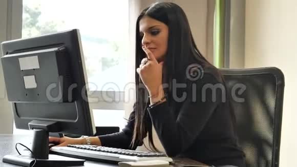 女办公室工作人员坐在办公桌上忙着两部电话视频的预览图