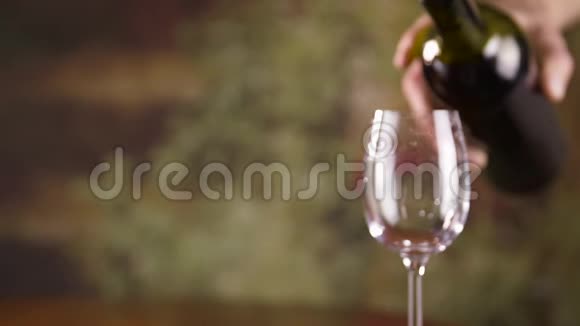 把雄手从瓶子里慢慢地往杯子里倒红酒视频的预览图