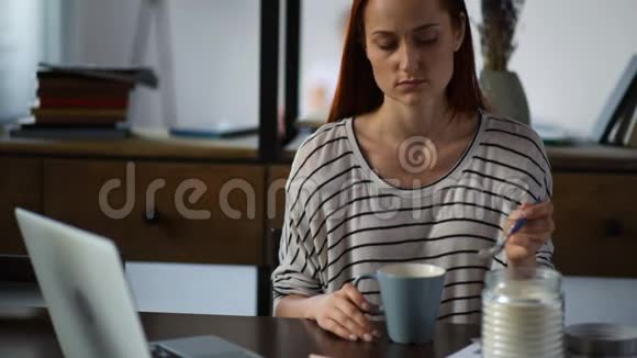 伤心的成年女人在家喝茶视频的预览图
