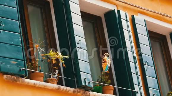 意大利威尼斯2017年9月7日玻璃窗户绿色百叶窗和五颜六色的儿童风车红砖墙视频的预览图