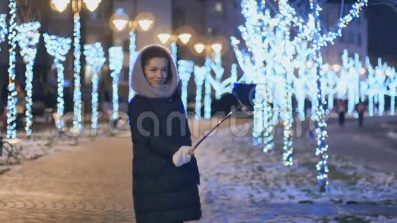 美丽的女孩在冬天的夜间灯光背景下自拍视频的预览图