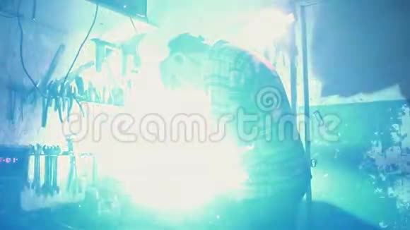 戴口罩的男性焊工在家庭车库工作金属火花缓慢移动视频的预览图