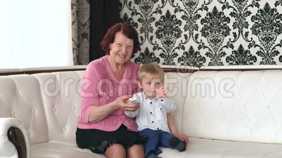 祖母和孙子一起看电视视频的预览图