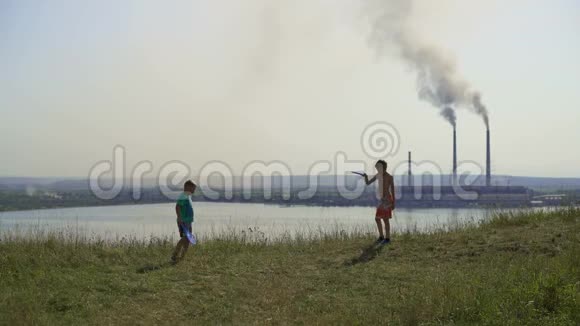 2017年乌克兰孩子们在热电厂的背景上玩耍晴朗的夏日黑烟蔓延视频的预览图